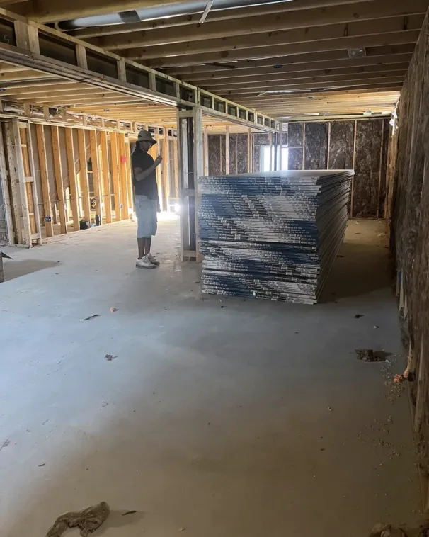 Drywall boards staged and stacked on site before hanging